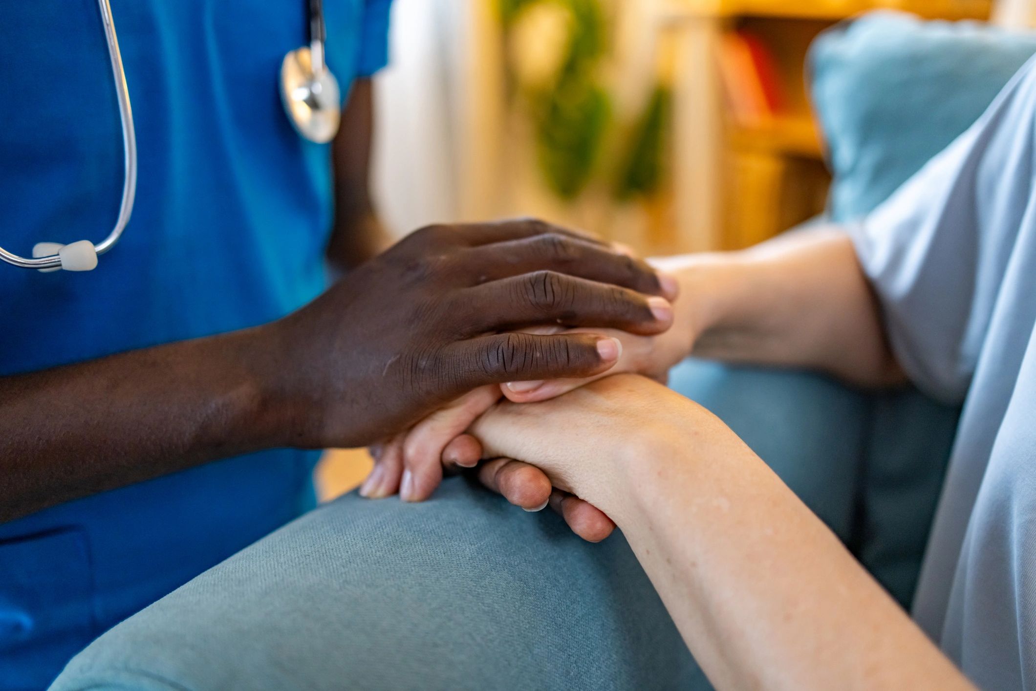 Nurse holding an elderly woman’s hands in a retirement home
