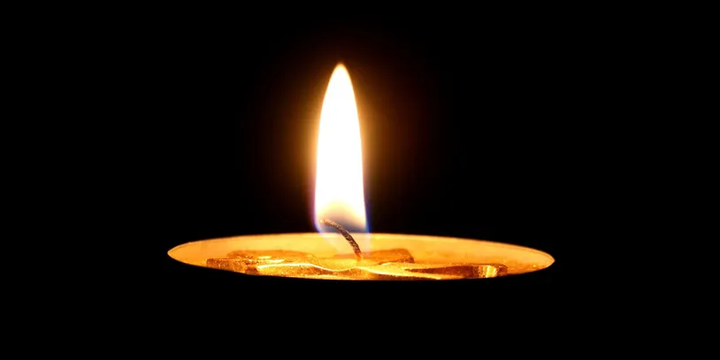 Lit candle flame against a black background