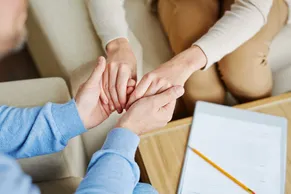 Supportive hands joined together, representing care and community support