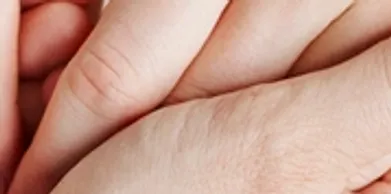 Close-up of two hands pressed together, symbolizing care and support