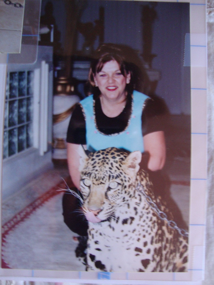 Portrait of a woman standing behind a leopard