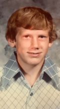 Portrait of a young person with short reddish hair