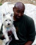 Portrait of a man holding a small white dog