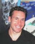Portrait of a smiling man against a dark background
