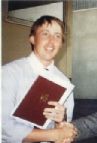 Portrait of a smiling person holding a red folder